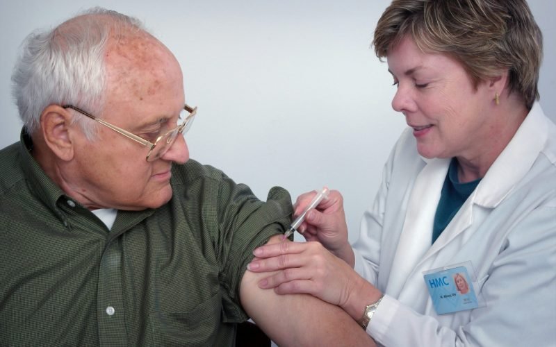 woman injecting syringe on mans arm